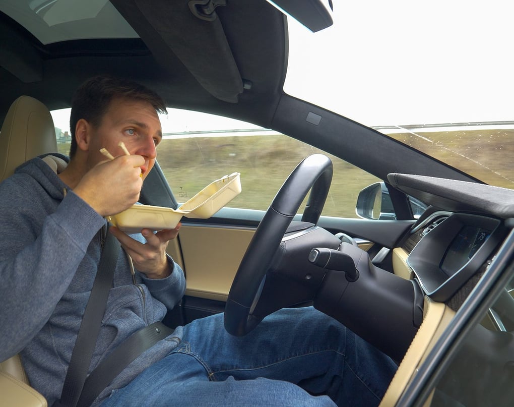 man eating in self-driving car